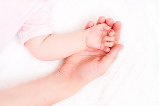 Beautiful sleeping baby with mom hand on white background - Фото, изображение