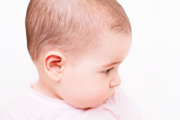 Interesado bebé mira a un lado en blanco primer plano retrato
 - Foto, imagen