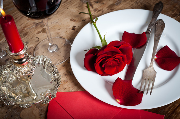 Apparecchiare la tavola con rose rosse sul piatto - celebrare San Valentino
 - Foto, immagini