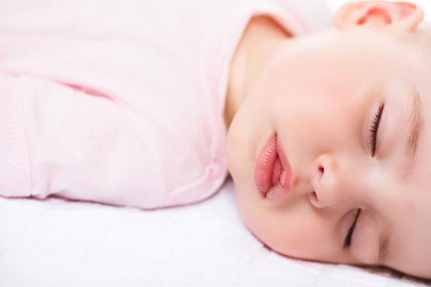 Adorable sleeping baby on white with pink suit - Valokuva, kuva