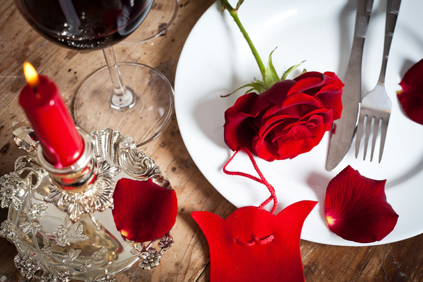 Tischdekoration mit roten Rosen auf Teller - zum Valentinstag - Foto, Bild