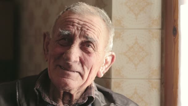 smiling old man looking at the camera - Materiał filmowy, wideo