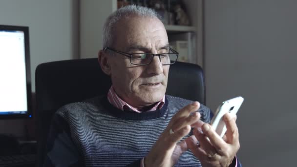old man composing a sms or chat message with modern mobile phone - Filmmaterial, Video