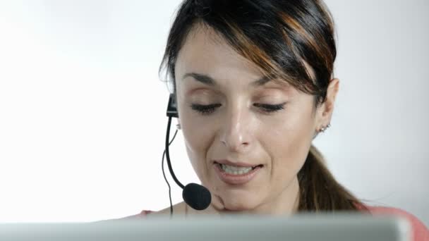 puhelinkeskus operaattori: nuori nainen työskentelee tietokoneen ja kuulokkeiden kanssa
 - Materiaali, video