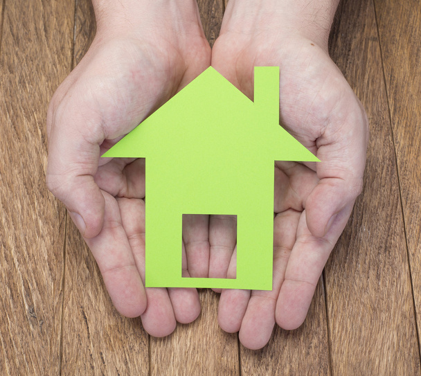 Ingatlan- és otthoni koncepció - férfi kezében papír ház zöld - Fotó, kép