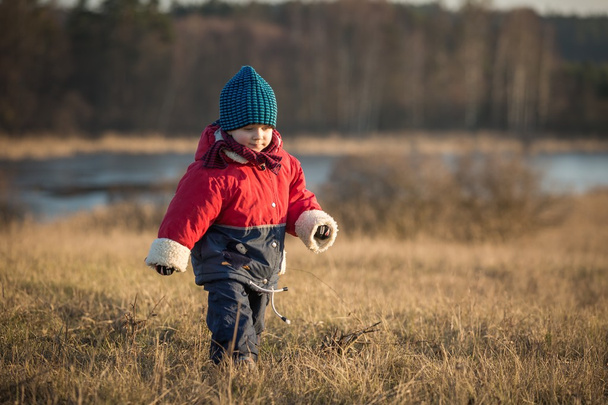 Šťastný chlapec hraje venkovní v jarní krajině u jezera - Fotografie, Obrázek