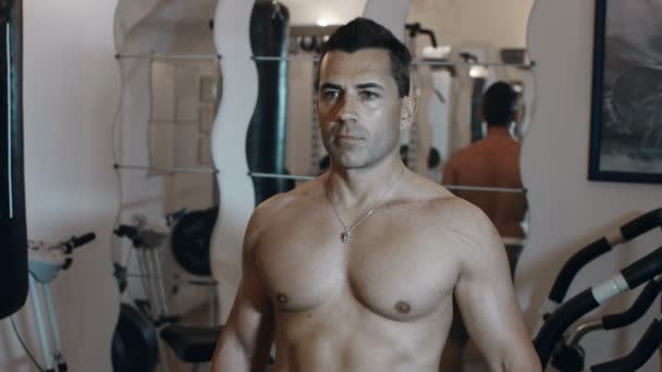 Topless volwassen mannetje gebruikt een gewicht uitoefent op een huisgymnastiek verblijven fit en stren - Video