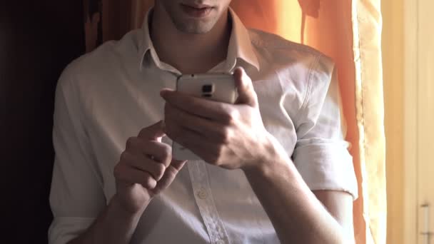 young man reading a message on a smartphone - Footage, Video