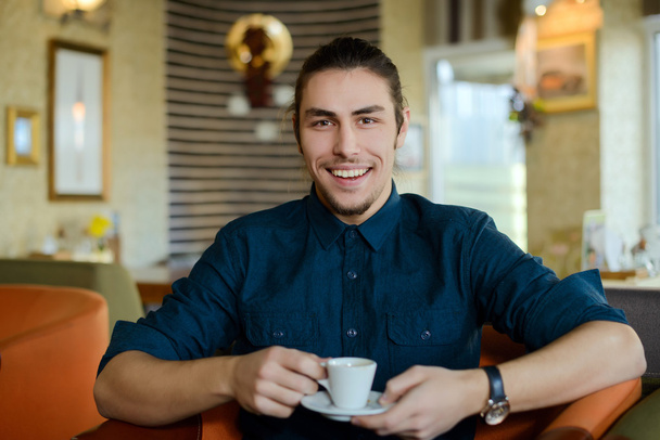 Mladý muž, pití kávy a pracují na notebooku v kavárně - Fotografie, Obrázek