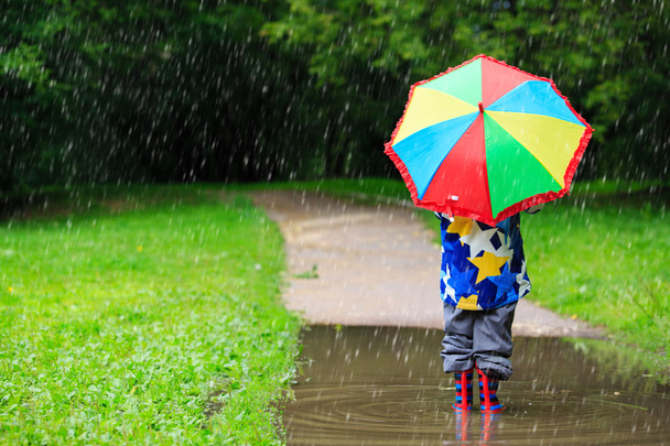 pequeño niño escondido detrás de colorido paraguas al aire libre
 - Foto, imagen