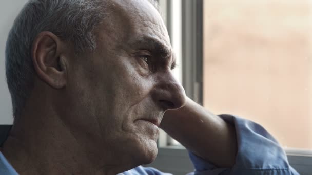 close up portrait of a man sitting alone and thoughtful near the window - Metraje, vídeo