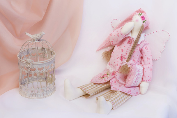 Tilda κούκλα σε ροζ χρώμα με ένα κλουβί παιχνίδι - Φωτογραφία, εικόνα