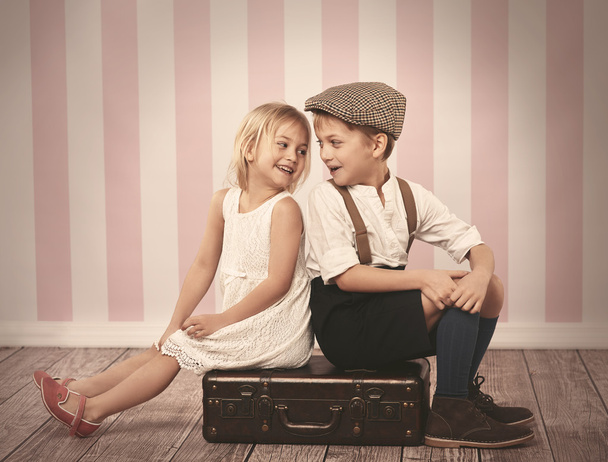 Дети сидят на деревянном чемодане
 - Фото, изображение