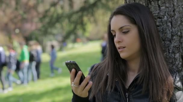 beautiful girl is answering unwillingly at the phone: smartphone, outdoor, call - Filmmaterial, Video