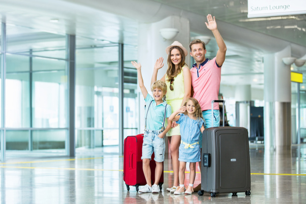 Onnellinen perhe ja matkalaukku lentokentällä
 - Valokuva, kuva