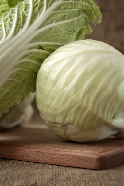 cabbage on a wooden board on a background sacking, burlap  - Foto, afbeelding