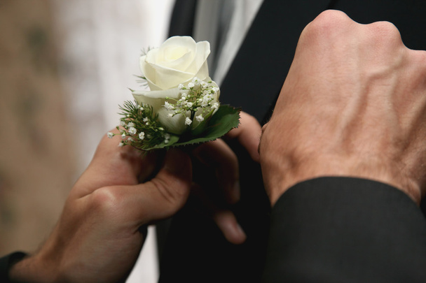 chacun aide à habiller la fleur de mariage pour costume de marié
 - Photo, image
