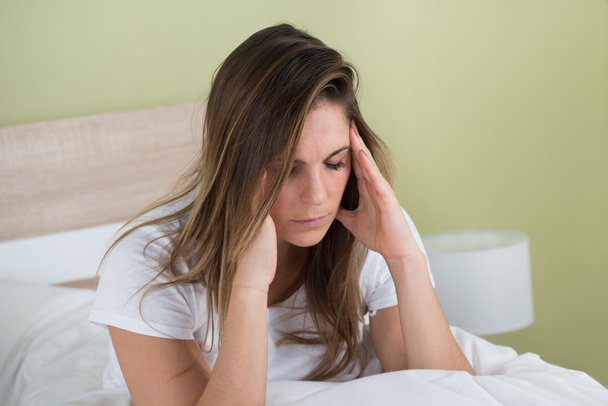 Woman With Headache Sitting On Bed - Фото, изображение