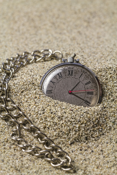 Годинник з ланцюгом на піску
. - Фото, зображення