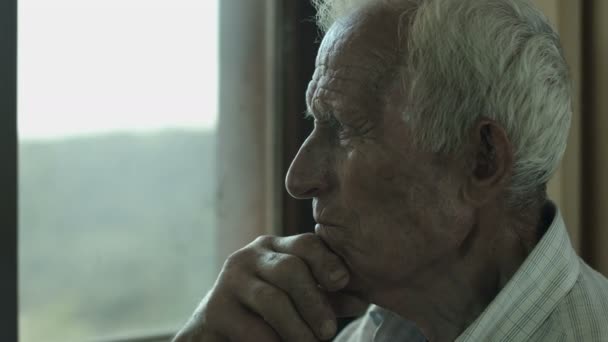 sad old man sitting alone - Materiał filmowy, wideo