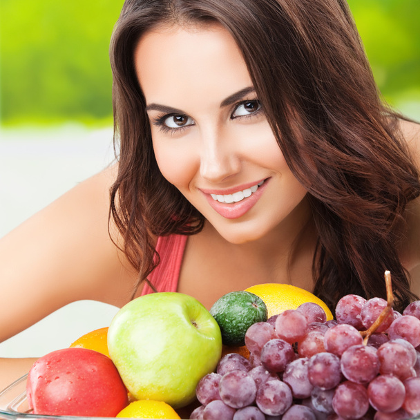 smiling woman with plate of fruits - 写真・画像