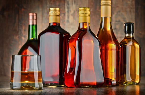 Glass and bottles of assorted alcoholic beverages - Photo, Image