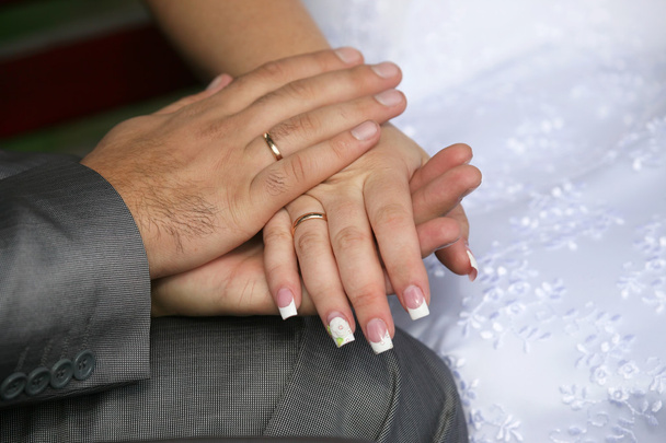 menyasszony és a vőlegény lévők megmutatják kezeiket viselése esküvői Jegygyűrűk - Fotó, kép