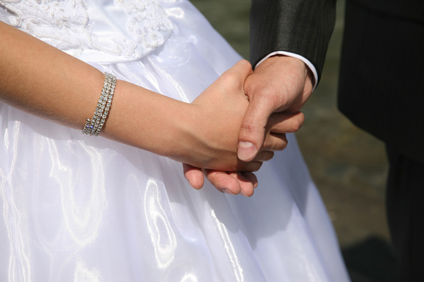 novio sostiene a la novia por la mano de cerca
 - Foto, imagen