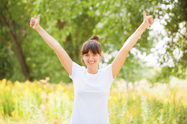 Woman in white t-shirt showing a thumbs up - Photo, Image