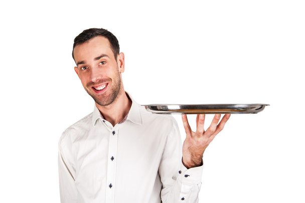 όμορφος σερβιτόρος κρατώντας ένα άδειο ασημένιο δίσκο, απομονωμένα σε λευκό  - Φωτογραφία, εικόνα
