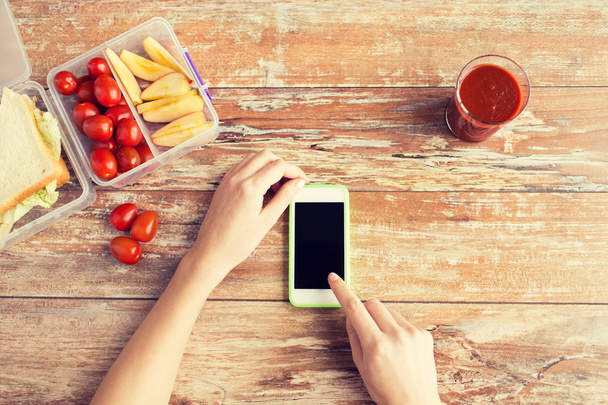 close up of hands with smartphone food on table - 写真・画像
