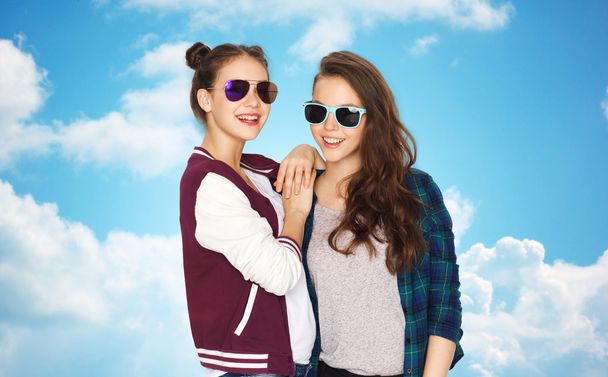 щасливі усміхнені красиві дівчата-підлітки в сонцезахисних окулярах
 - Фото, зображення