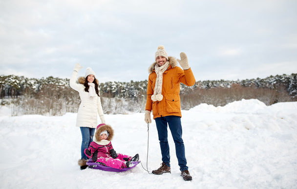 happy family with sled walking in winter outdoors - Photo, Image