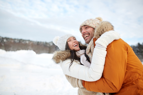 happy couple hugging outdoors in winter - 写真・画像