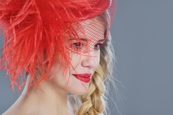 Vrouw mode portret in rood vintage hoed met veren - Foto, afbeelding