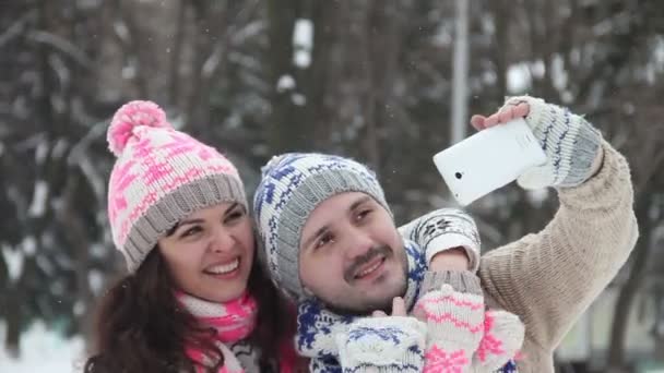 Pareja amorosa en invierno al aire libre haciendo selfie en el teléfono inteligente
 - Imágenes, Vídeo