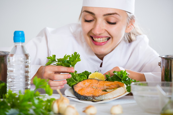 jefe femenino con pescado frito en el plato
 - Foto, Imagen