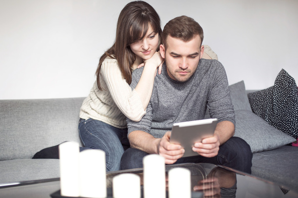 Couple sitting on sofa with digital tablet - Photo, Image