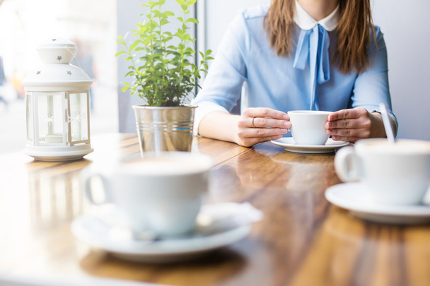 Γυναίκα στο τραπέζι σε καφέ με latte - Φωτογραφία, εικόνα