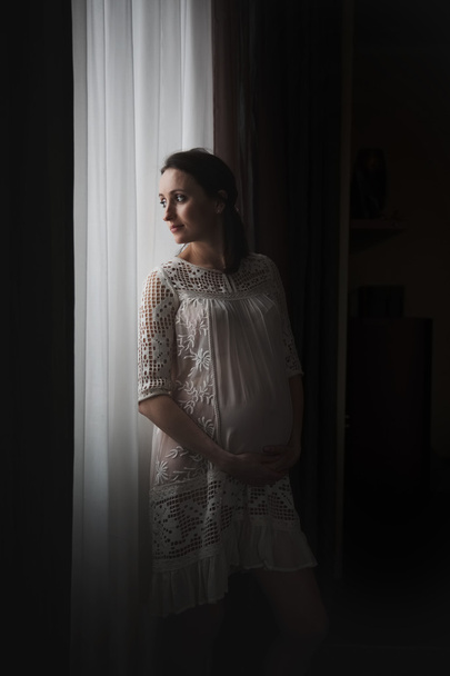 Happy pregnant woman near a window - Valokuva, kuva