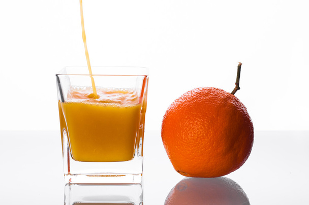 Orange juice pouring into glass - Fotó, kép