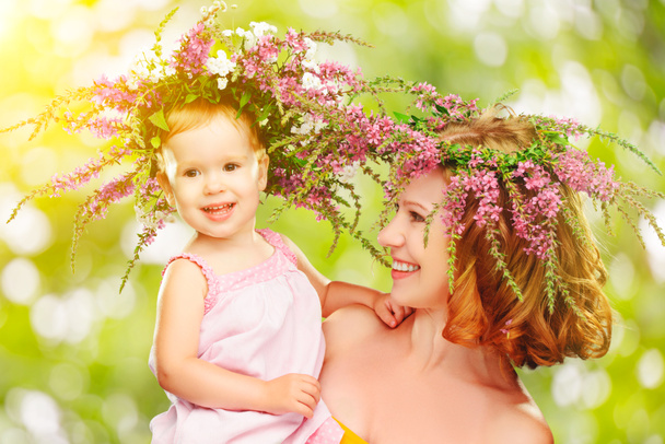 happy laughing daughter hugging mother in wreaths of summer flow - Photo, Image