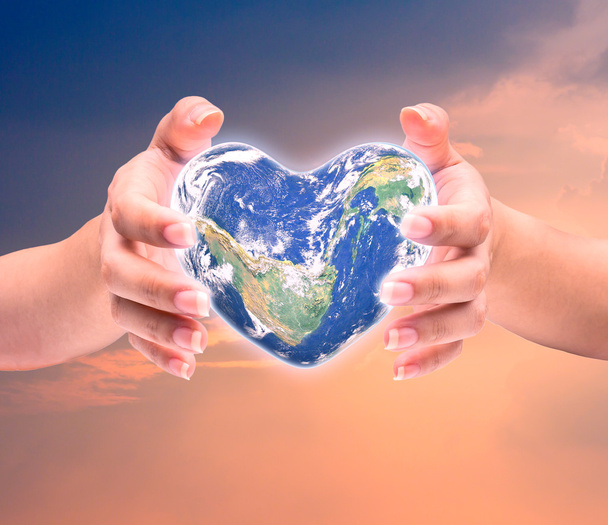 Світ у формі серця з над жінками людськими руками на розмитому Нату
 - Фото, зображення