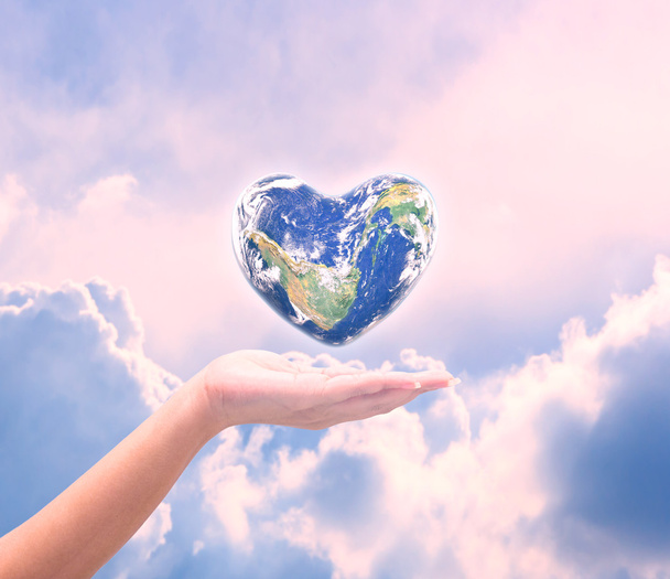 Svět ve tvaru srdce s více než ženy lidské ruce na rozmazané natu - Fotografie, Obrázek