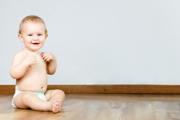 Cute smiling baby sitting at home. - Foto, Bild