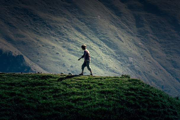 Young girl walking on the top up against the mountain  - Foto, Bild