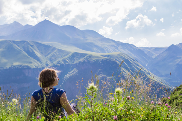 Жінка сидить на вершині гори
 - Фото, зображення