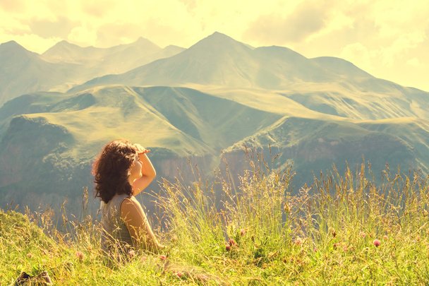 Mujer sentada en la cima de una montaña
 - Foto, Imagen