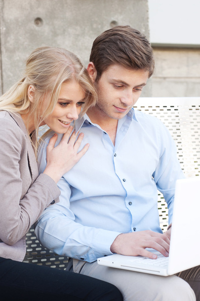 Retrato de una feliz pareja profesional joven utilizando el ordenador portátil
 - Foto, imagen