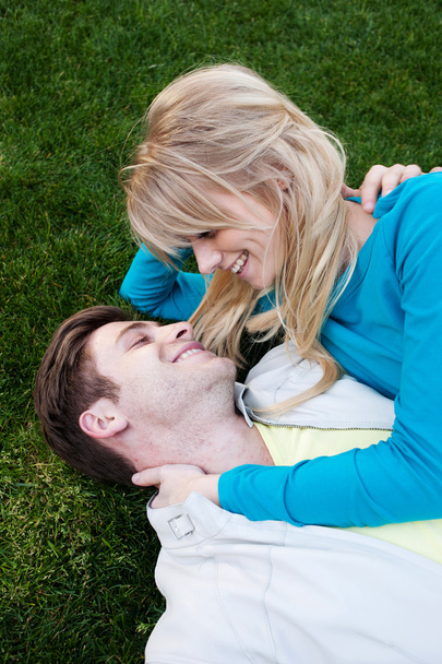 Jovem casal apaixonado deitado na grama
 - Foto, Imagem